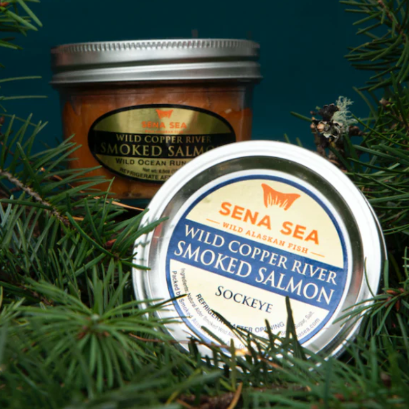 Two jars of Sena Sea wild copper river smoked salmon surrounded by greenery.